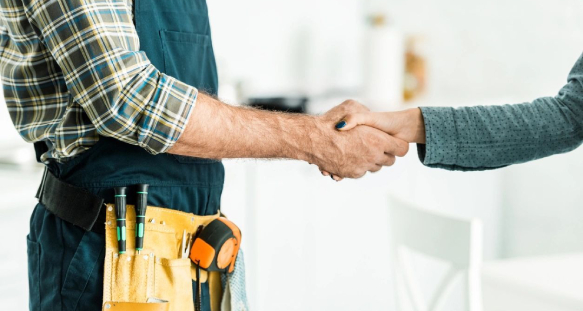 Plumber and client shaking hands