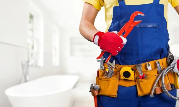 Plumber with tool belt standing in bathroom